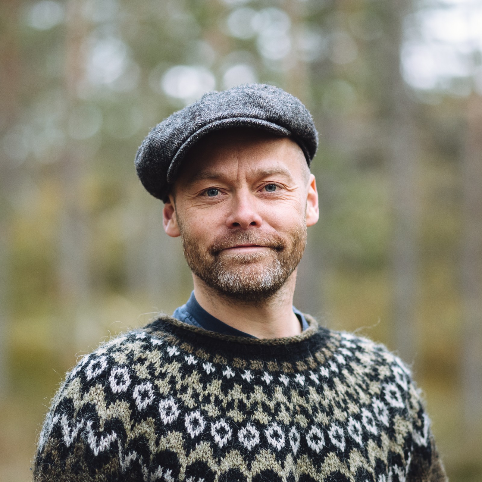 Portrett av Mikkel Soya med hatt foran en skog